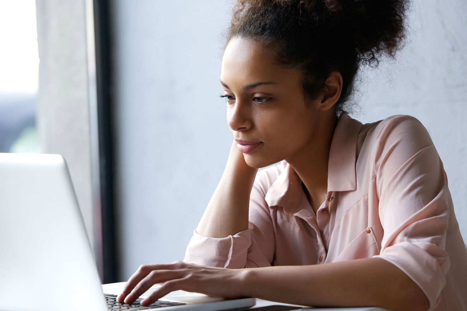 Business person on laptop completing online dyslexia test - QS Dyslexia Tests