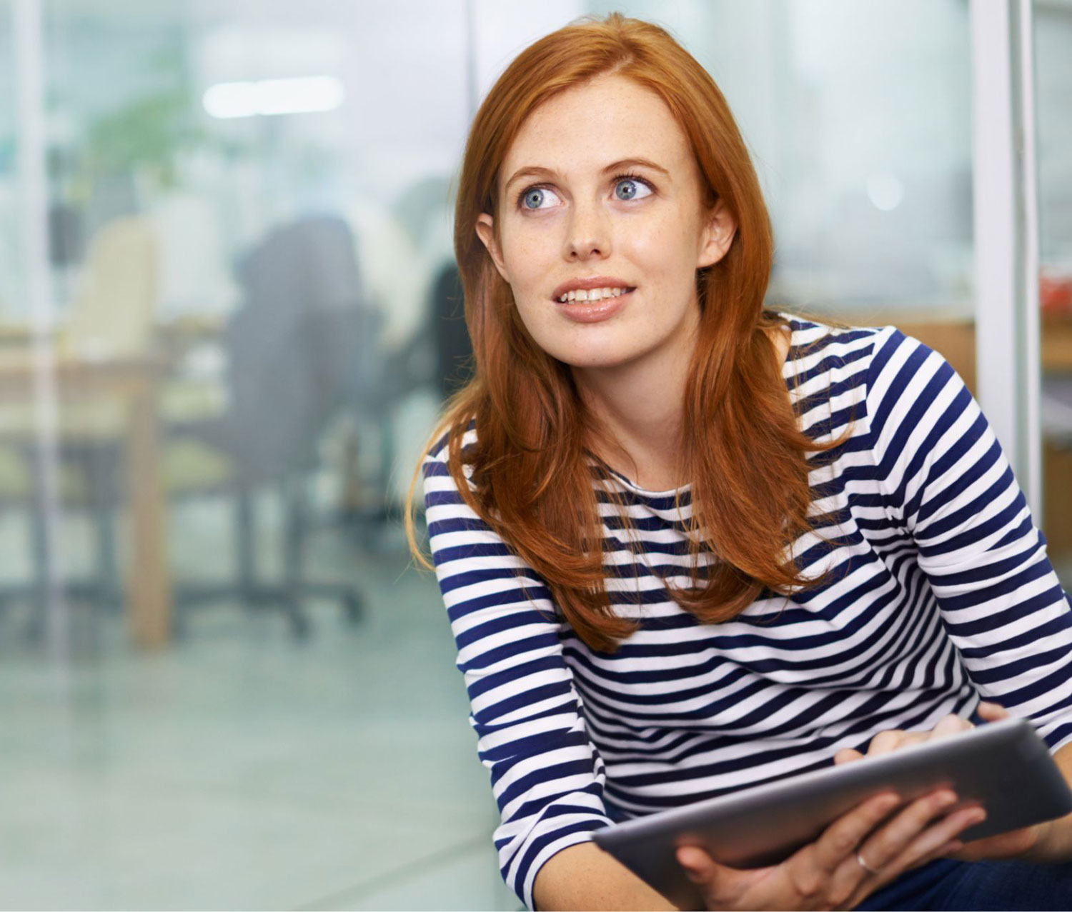 Woman thinking while completing online dyslexia test on IPad - QS Dyslexia Tests